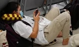 Khách nằm, ngồi giữa sàn đợi lên máy bay tại Cảng hàng không Nội Bài