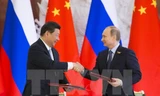 Chủ tịch Tập Cận Bình (trái) và Tổng thống Vladimir Putin trao đổi văn kiện sau lễ ký các thỏa thuận hợp tác song phương. Nguồn: THX/TTXVN