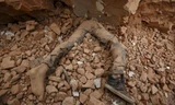 Thân thể của một nạn nhân nằm kẹt trong đống đổ nát ở Kathmandu. Ảnh: Reuters