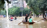 Lũ lụt dâng cao khiến người dân phải chèo thuyền đi lại ở huyện Dung Thủy, tỉnh Quảng Tây. Ảnh: Xinhua