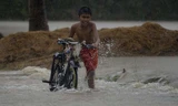 Cậu bé dắt xe đạp trên phố ngập nước ở Ineangan, Bambang, Nueva Viscaya