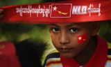 Một em bé đeo băng đỏ ủng hộ bà Aung San Suu Kyi, lãnh đạo NLD, tại điểm bầu cử.