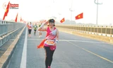Chị Trần Thị Phượng xúc động khi chạy giữa hai hàng cờ Tổ quốc tại Tiền Phong Marathon Phú Yên 