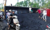 Xe tải lật ngửa khiến hàng chục tấn than đổ ra đường.