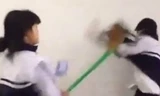 Hình ảnh nữ sinh tấn công nam sinh cùng lớp bằng chổi quét nhà. Ảnh cắt từ video.