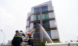 Cảnh sát chữa cháy dùng xe thang dập đám cháy. Ảnh: Nguyệt Triều.
