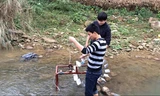 Hai "nhà phát minh" đang thử chạy thiết bị đưa nước lên cao không cần dùng điện tại một con suối.