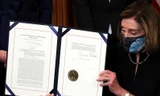 Chủ tịch Hạ viện Nancy Pelosi trưng ra văn bản thông qua việc luận tội tổng thống Trump sau khi ký phê chuẩn ảnh: Reuters 