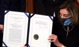 Chủ tịch Hạ viện Nancy Pelosi trưng ra văn bản thông qua việc luận tội tổng thống Trump sau khi ký phê chuẩn ảnh: Reuters 