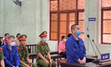 Bị cáo Nông Văn Hưởng (đứng) và Nông Ích Thạch ( áo xanh, ngồi) khai báo trước tòa -Ảnh: T.0