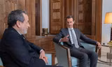 Các tay súng nổi dậy đi qua chiếc xe bọc thép của quân đội Syria bị bỏ lại trên đường cao tốc ở Khan Sheikhoun, phía tây nam Aleppo, ngày 1/12. (Ảnh: AP)
