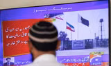 Một người đang theo dõi tin tức trên TV sau khi Bộ Ngoại giao Pakistan cho biết nước này vừa tấn công các mục tiêu trong đất của Iran 18/1. (Ảnh: Reuters)