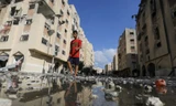 Một người Palestine bước đi trên con phố ở Khan Younis ngày 11/8. (Ảnh: Reuters)