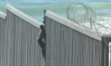 Người di cư ở Mexico trèo tường biên giới để vào Mỹ