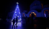Một cây thông Noel trước nhà thờ Cơ đốc ở Ukraine đêm 24/12. (Ảnh: Reuters)