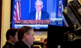 Hình ảnh chủ tịch Fed Jerome Powell được phát trên màn hình tại sàn chứng khoán New York khi thông báo về việc tăng lãi suất. (Ảnh: Reuters)