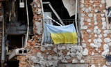 Quốc kỳ Ukraine trên ban công một tòa nhà chung cư bị hư hỏng nặng ở Irpin ngày 16/6. (Ảnh: CNN)