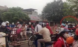 Đoàn tàu chở hàng buộc phải dừng từ xa khi hàng chục người điều khiển xe máy vượt rào chắn băng đường ray trên quốc lộ 21B sáng 13/4. Ảnh: Lê Anh Tú.