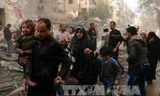 Người dân Syria sơ tán sau các cuộc không kích của quân đội chính phủ vào các mục tiêu của phiến quân ở thành phố Aleppo ngày 13/1. Ảnh: AFP/TTXVN.