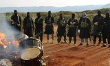Chiến binh IS ở Libya đốt một nhạc cụ trong video tuyên truyền. Ảnh: clarionproject.org.