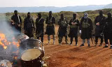 Chiến binh IS ở Libya đốt một nhạc cụ trong video tuyên truyền. Ảnh: clarionproject.org.