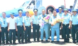 Đồng đội chúc mừng đại tá Lê Kiêm Toàn và thượng tá Nguyễn Đức Hảo (hai người cầm hoa) trở về đơn vị sau khi thực hiện nhiệm vụ bay chuyển sân hạ cánh ở Trường Sa trên một chiếc Casa-212, đầu tháng 6/2016.