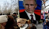Người dân giơ cao ảnh chân dung Tổng thống Nga tại cuộc tuần hành nhân kỷ niệm Ngày Vệ quốc ở Sevastopol thuộc bán đảo Crimea ngày 23/2. Ảnh: AFP/TTXVN.