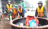 BĐBP TT-Huế dùng thuyền di chuyển dân vượt qua vùng nước sâu tại Huế ẢNH: P.V  