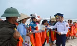 Vùng CSB 1 tặng cờ Tổ quốc và cấp phát tờ rơi tuyên truyền cho bà con ngư dân ở huyện Lệ Thủy (Quảng Bình). Ảnh: M.T