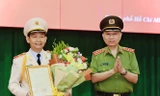 Đại tướng Tô Lâm, Bộ trưởng Bộ Công an thừa uỷ quyền của Chủ tịch nước trao quyết định thăng cấp hàm cho Phó Giám đốc Công an TPHCM Đinh Thanh Nhàn. Ảnh CA