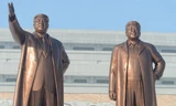 Tượng cố Chủ tịch Kim Jong Il (bên phải) trước khi thay áo