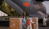 Các nhân viên y tế Philippines dỡ lô vắc-xin do máy bay quân sự Trung Quốc đưa đến ảnh: Reuters 