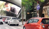 Điểm trông xe phố Thái Phiên với biển cấp phép xô lệch và nhân viên thò đầu qua cửa kính ô tô (ảnh nhỏ) yêu cầu chủ xe trả 70.000 đồng/lượt Ảnh: A.Trọng 