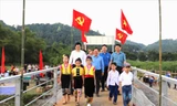 Đại biểu, người dân, học sinh xã Chi Khê, huyện Con Cuông trên cây cầu vừa khánh thành