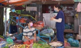 Nhân viên y tế nhắc nhở các tiểu thương chợ truyền thống thực hiện quy định về phòng chống dịch COVID-19