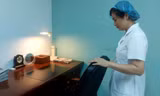Thiếu tá, điều dưỡng viên Nguyễn Thị Hồng lặng đi bên bàn làm việc của Tổng Bí thư Nguyễn Phú Trọng trong phòng bệnh