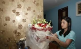 Vợ xạ thủ Hoàng Xuân Vinh bên bó hoa tặng chồng.