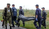 Các nhân viên cứu hộ đưa xác nạn nhân vụ rơi máy bay MH17 rời hiện trường. (Ảnh: AFP/TTXVN)