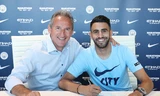 Riyad Mahrez đặt bút ký vào hợp đồng với Man City trước sự chứng kiến của Giám đốc thể thao Txiki Begiristain 