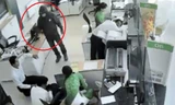 Tên cướp liên tục nạt nộ, dọa bắn các nhân viên, yêu cầu gom tiền bỏ vào 2 túi xách. Ảnh: Cắt từ video. 
