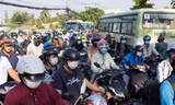 Người dân TPHCM bồng con qua dòng xe kẹt để đến trường
