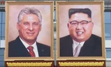 Tranh chân dung của ông Kim Jong-un được treo cạnh tranh chân dung Chủ tịch Cuba Miguel Diaz-Canel. Bức tranh vẽ ông Kim cười tươi trong bộ vest mang phong cách phương Tây. Ảnh: KCTV
