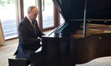 Tổng thống Putin trổ tài chơi piano trước đông đảo báo giới. Ảnh: Sputnik