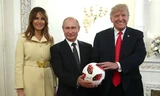 Tổng thống Mỹ Trump và phu nhân chụp ảnh cùng Tổng thống Nga Putin bên trái bóng World Cup. Ảnh: Tass
