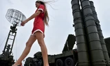 Một cô gái trẻ bước ngang qua hệ thống phòng không S-400 tại triển lãm quân sự. Ảnh: AFP