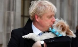 Thủ tướng Anh Boris Johnson ôm chó cưng đi bỏ phiếu. Ảnh: Reuters