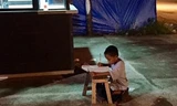 Bức ảnh cậu bé nghèo học bên vệ đường lay động lòng người