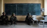 Binh lính Philippines giấu mình trong một lớp học để theo dõi nhóm phiến quân Maute hôm qua, 7/6. Ảnh: AFP