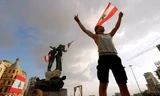 Một người biểu tình giương cờ Li-băng trên Quảng trường Liệt sĩ ngày 9/8 