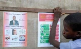 Một cậu bé đứng cạnh tấm áp phích tuyên truyền của chính phủ về bệnh Ebola ở chợ Duwala, Monrovia ngày 17/8/2014.